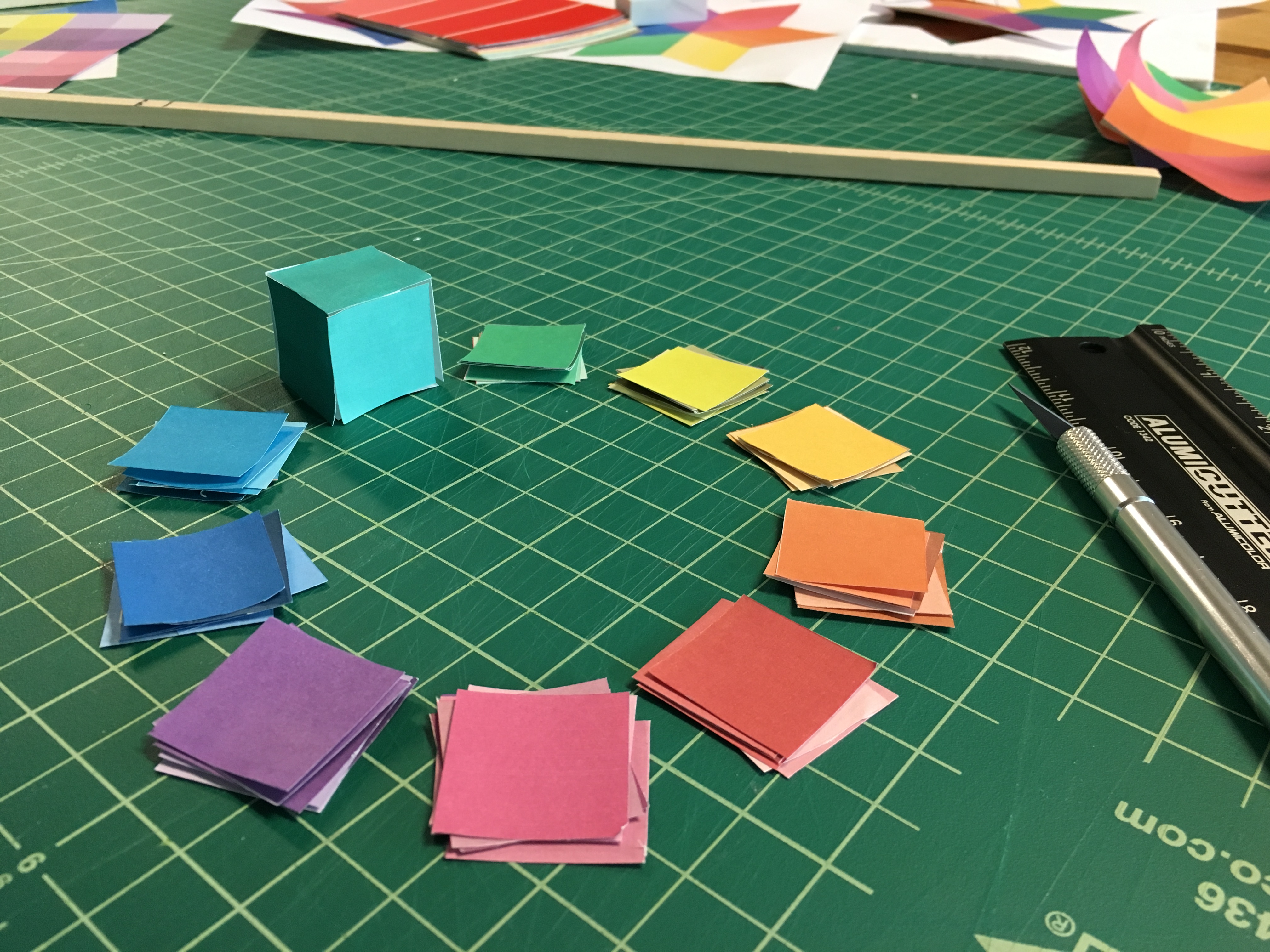 An early prototype of a color wheel made of dice, made of printed paper cut-outs glued together into cubes.