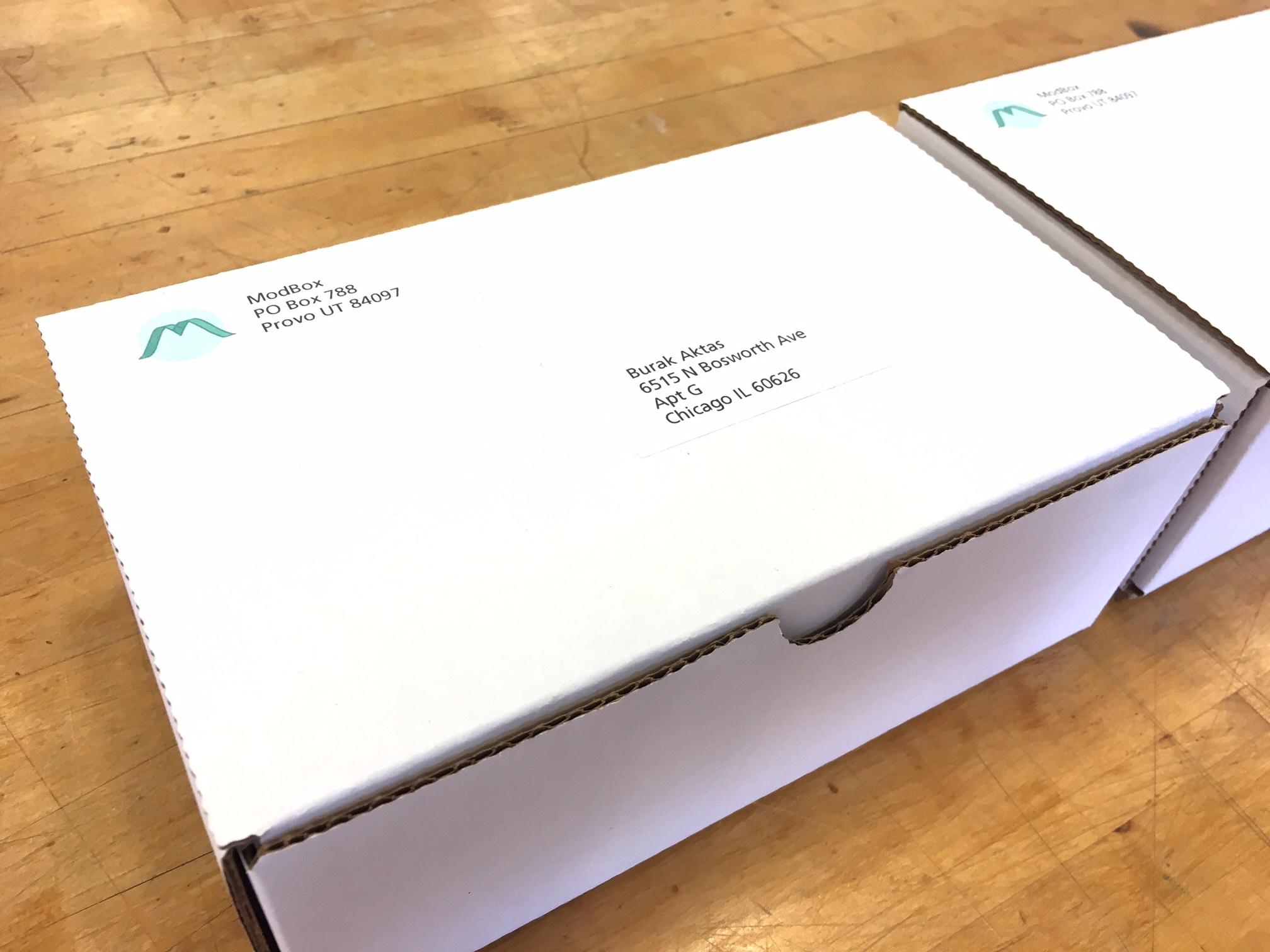 A white box is return addressed from a company called ModBox in Provo, Utah.